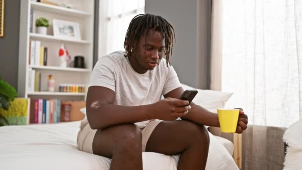 Afrika Amerika Pria Menggunakan Smartphone Minum Kopi Kamar Tidur — Stok Video