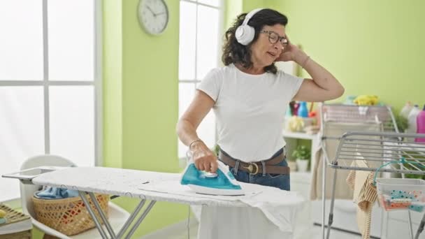 Mujer Hispana Mediana Edad Escuchando Música Planchando Ropa Bailando Lavandería — Vídeos de Stock