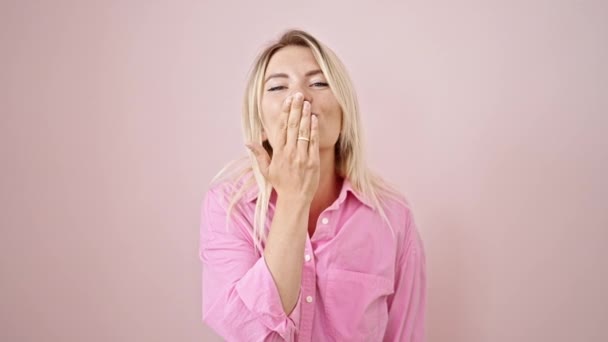 Jong Blond Vrouw Glimlachen Zelfverzekerd Blazen Kus Geïsoleerde Roze Achtergrond — Stockvideo