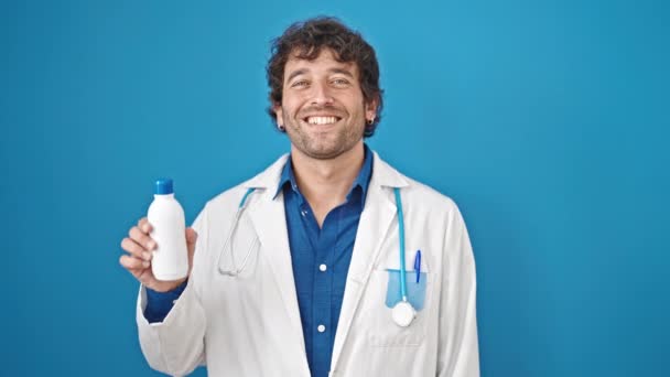 Молодий Іспаномовний Лікар Посміхається Впевнено Тримає Пляшку Ліків Над Ізольованим — стокове відео