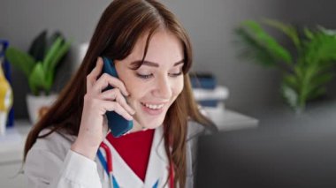 Genç İspanyol kadın doktor klinikte bilgisayarla konuşuyor.