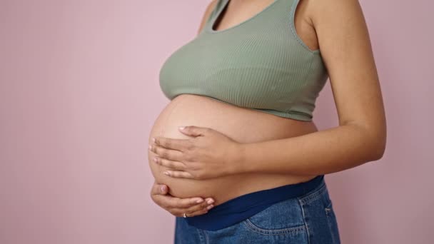 Молодая Беременная Женщина Касается Живота Изолированном Розовом Фоне — стоковое видео