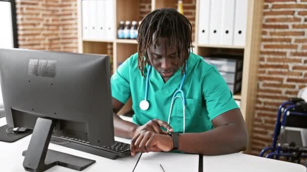 Africano Americano Homem Médico Olhando Assistir Com Rosto Sério Clínica — Vídeo de Stock