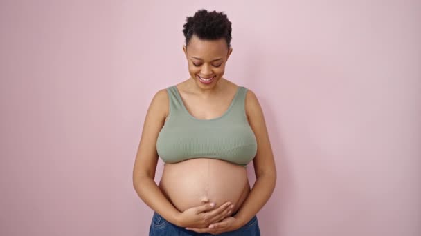 Молодая Беременная Женщина Улыбается Уверенно Трогательный Живот Изолированном Розовом Фоне — стоковое видео