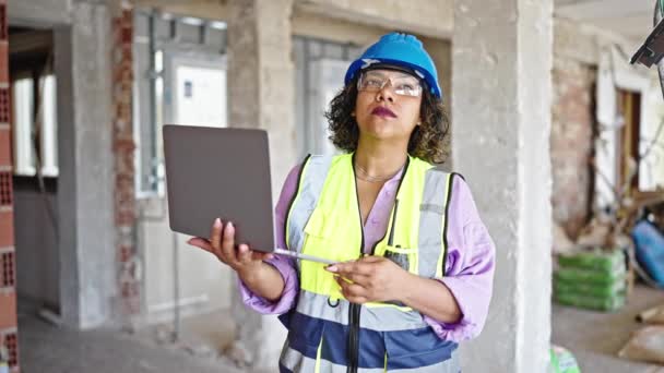 建筑工地年轻漂亮的拉丁女建筑工人用手提电脑用对讲机交谈 — 图库视频影像