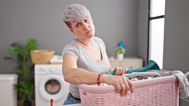 Çamaşır Odasında Elinde Giysileri Olan Yorgun Yüzlü Genç Bir Kadın — Stok video