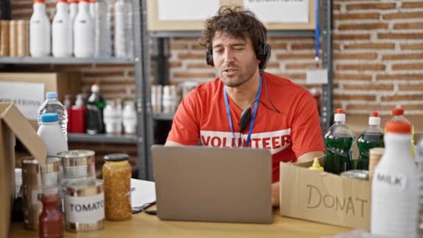Joven Hombre Hispano Voluntario Escribiendo Portapapeles Teniendo Videollamada Centro Caridad — Vídeos de Stock