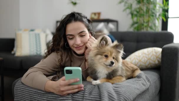 Wanita Muda Hispanik Dengan Anjing Menggunakan Smartphone Berbaring Sofa Rumah — Stok Video