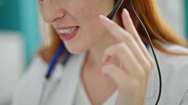 Młoda Ruda Lekarz Robi Wideo Rozmowy Zestaw Słuchawkowy Klinice — Wideo stockowe