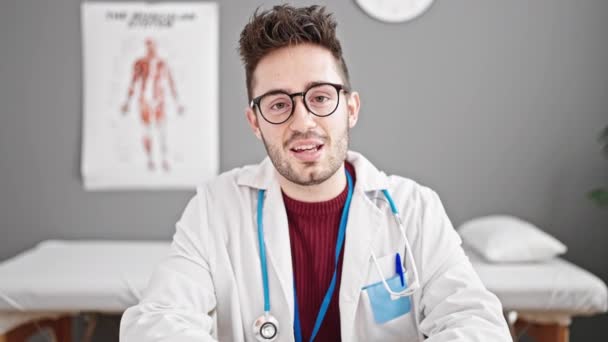 若いヒスパニックの男性医師 クリニックで自信を持って話す笑顔 — ストック動画