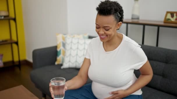 Νεαρή Έγκυος Γυναίκα Πίνοντας Ποτήρι Νερό Κάθεται Στον Καναπέ Στο — Αρχείο Βίντεο
