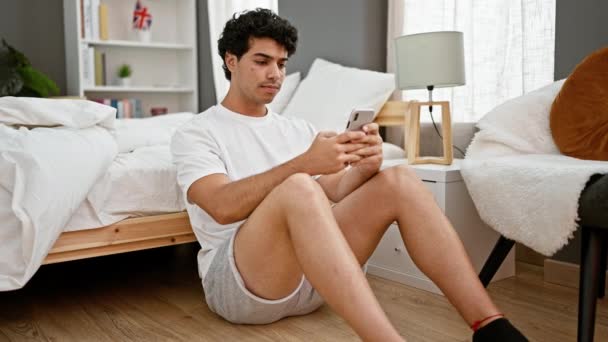 Genç Latin Adam Yatak Odasında Akıllı Telefon Kullanarak Yerde Otururken — Stok video