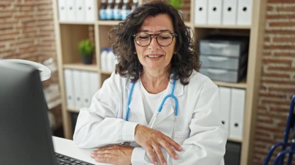 Orta Yaşlı Spanyol Kadın Doktor Klinikte Masada Oturuyor Gözlüğünü Çıkarıyor — Stok video