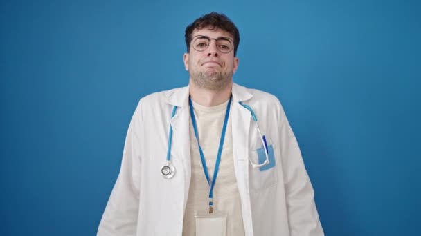 Joven Médico Hispano Pie Despistado Sobre Fondo Azul Aislado — Vídeo de stock