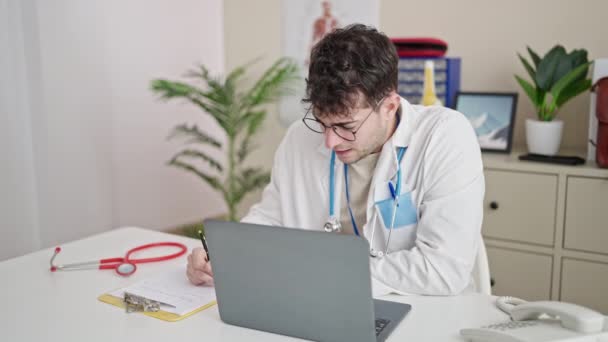 Jovem Hispânico Homem Médico Usando Laptop Escrevendo Relatório Médico Clínica — Vídeo de Stock