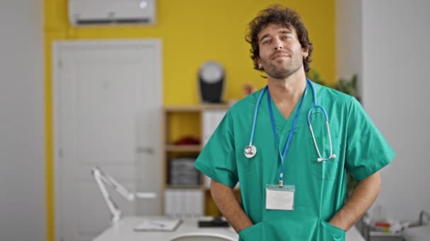 Молодий Іспаномовний Лікар Посміхається Впевнено Стоячи Клініці — стокове відео