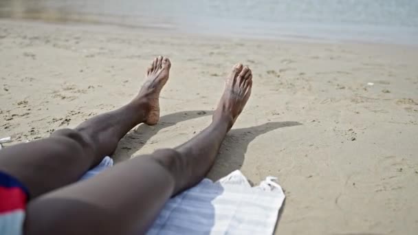 Afrykański Amerykański Mężczyzna Turysta Leżący Ręczniku Porusza Stopami Plaży — Wideo stockowe