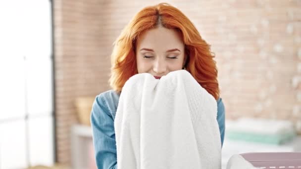 Junge Rothaarige Frau Lächelt Zuversichtlich Riechend Sauberes Handtuch Der Waschküche — Stockvideo
