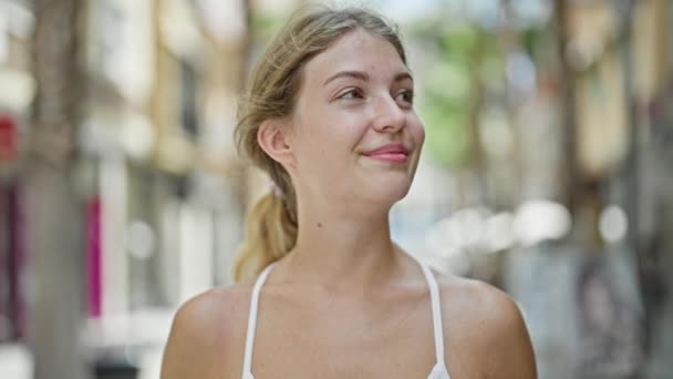 Junge Blonde Frau Lächelt Selbstbewusst Mit Sonnenbrille Auf Der Straße — Stockvideo