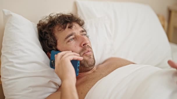 Молодий Іспаномовний Чоловік Лежить Ліжку Сорочки Розмовляючи Смартфоні Дивлячись Засмучений — стокове відео