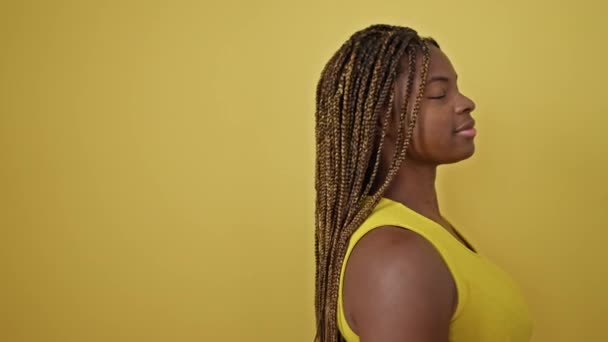 Mujer Afroamericana Sonriendo Confiada Pie Sobre Fondo Amarillo Aislado — Vídeo de stock