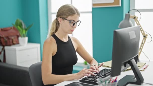 若い金髪女性ビジネスワーカー オフィスで見ているコンピュータを使用して — ストック動画