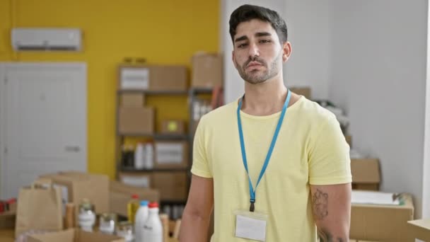 Joven Hombre Hispano Voluntario Sonriendo Confiado Pie Centro Caridad — Vídeo de stock