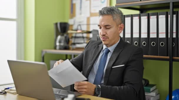 若いヒスパニック系男性ビジネスワーカーがオフィスで祝う手紙を読む — ストック動画