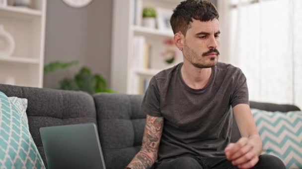 Young Hispanic Man Talking Smartphone Using Laptop Home — Stockvideo