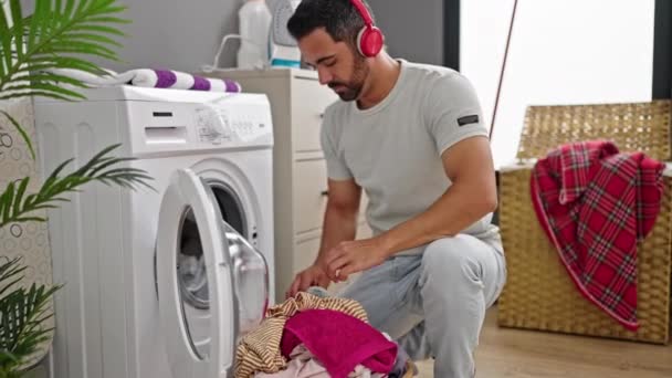 Νεαρός Ισπανός Που Ακούει Μουσική Πλένει Ρούχα Στην Τραπεζαρία — Αρχείο Βίντεο