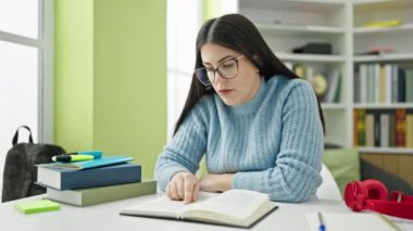 Kütüphane Üniversitesi 'nde kitap okuyan genç İspanyol kadın öğrenci.