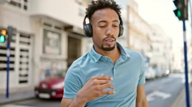 Sokak ortasında müzik dinleyen ve dans eden Afrikalı Amerikalı bir adam.