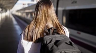 Tren istasyonunda yürüyen güzel İspanyol bir kadın.