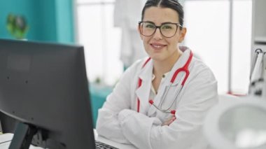 Genç, güzel İspanyol kadın doktor klinikte kendinden emin gülümsüyor.