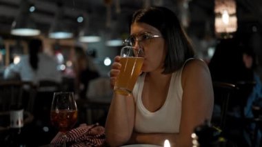 Genç ve güzel İspanyol kadın restoranda bira içiyor.
