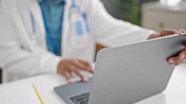 Klinikte laptopunu kullanan Afrikalı Amerikalı bir doktor.