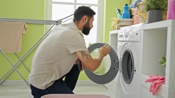 Jovem Hispânico Homem Segurando Smartphone Começando Máquina Lavar Roupa Lavanderia — Vídeo de Stock