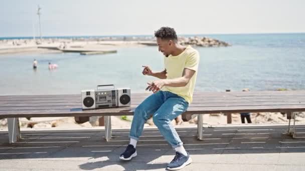 アフリカ系アメリカ人の男が海辺で自信を持って踊る — ストック動画