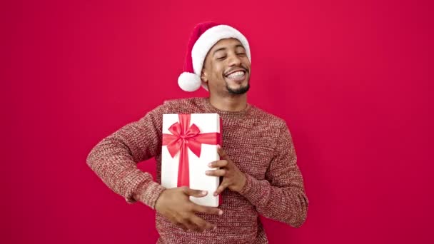 Afro Amerikaanse Man Met Kerst Geschenk Geïsoleerde Rode Achtergrond — Stockvideo