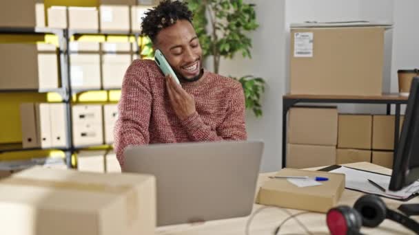 Αφροαμερικάνος Εργαζόμενος Ηλεκτρονικού Εμπορίου Μιλώντας Στο Smartphone Γράφοντας Στο Πακέτο — Αρχείο Βίντεο