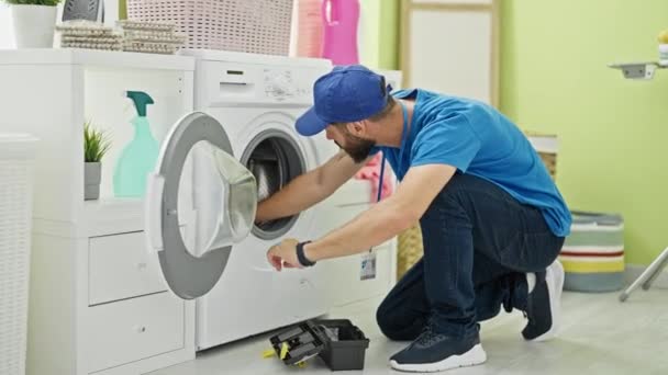 洗濯室で洗濯機を修理する若いヒスパニック系の男性技術者 — ストック動画
