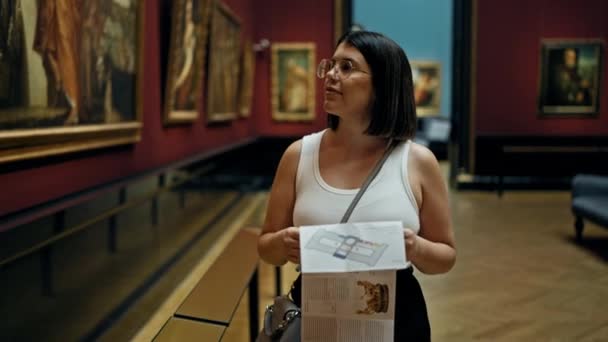 Νεαρή Όμορφη Ισπανίδα Επισκέπτρια Γκαλερί Διαβάζει Φυλλάδια Στο Μουσείο Τέχνης — Αρχείο Βίντεο