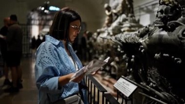 Genç ve güzel İspanyol kadın Viyana 'daki Imperial Crypt' de broşür okuyarak lahiti ziyaret ediyor.