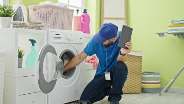 Νεαρός Ισπανός Τεχνικός Επισκευάζει Πλυντήριο Κρατώντας Touchpad Στο Πλυσταριό — Αρχείο Βίντεο