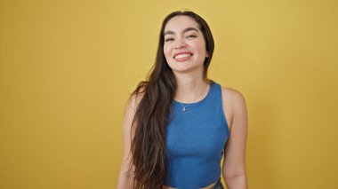 Young beautiful hispanic woman smiling confident standing over isolated yellow background