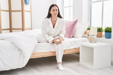 Genç İspanyol kadın diz ağrısı çekiyor. Yatak odasında oturuyor.