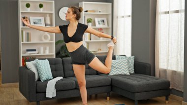 Genç, güzel İspanyol kadın evde yoga eğitimi veriyor.