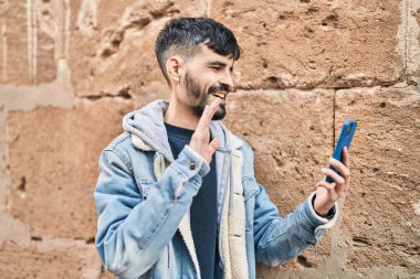 Latin asıllı genç adam gülümsüyor.