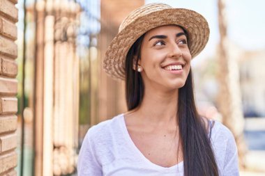Young hispanic woman tourist smiling confident standing at street