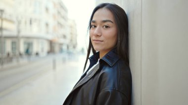 Sokakta ciddi bir ifadeyle duran genç, güzel İspanyol kadın.